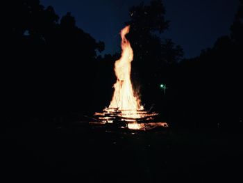 Illuminated bonfire against sky at night