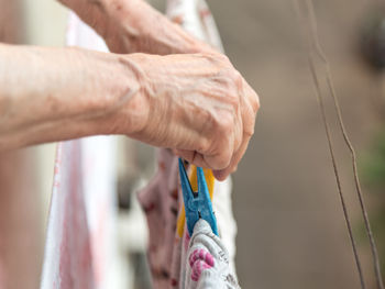 Cropped hand of man holding rope