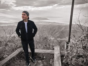 Full length of teenage boy standing on land against sky