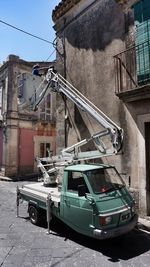 Cars on street in city against sky