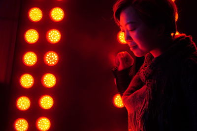 Smiling woman against disco lights in nightclub