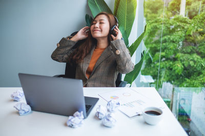 Portrait of young woman using laptop at table