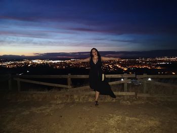 Full length of woman standing against sky in city