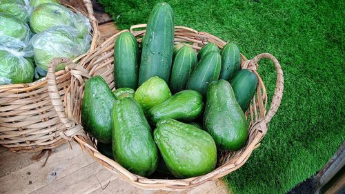 High angle view  fresh green chayote and cucumbers in rattan baskets for sale in market