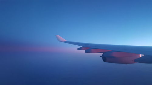 Close-up of airplane wing against clear blue sky