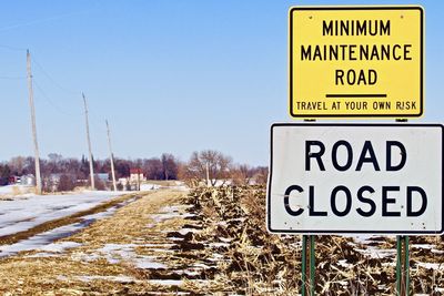 Road sign on snow covered land