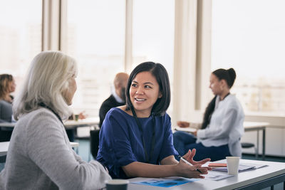 Smiling women sitting together in class