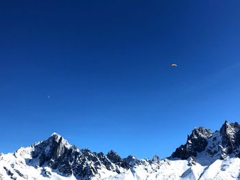 Scenic view of snowcapped mountains against clear blue sky