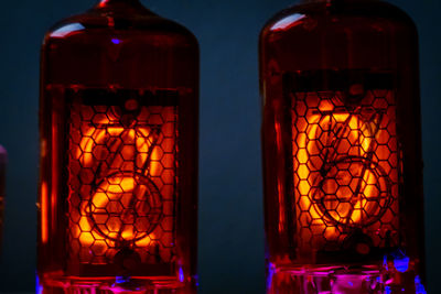 Close-up of illuminated candles on glass