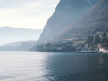 Scenic view of sea by mountains against sky