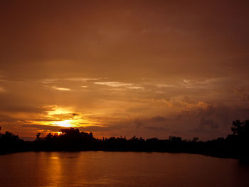 Scenic view of lake against orange sky