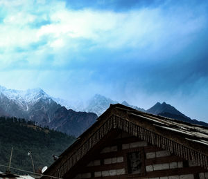 Houses on snowcapped mountain against sky