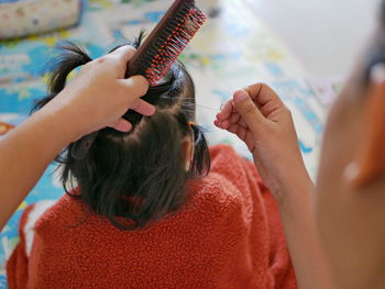 High angle view of mother combing at home