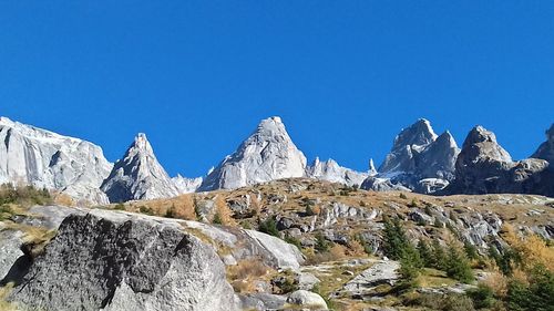 Panoramic view of snowcapped mountains against clear blue sky
