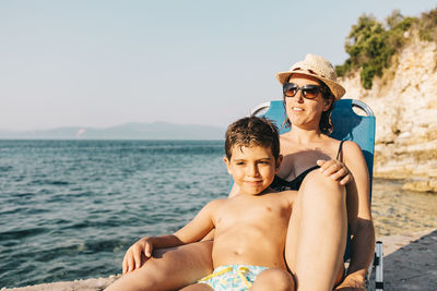 Mother and son relaxing on the coast near the sea