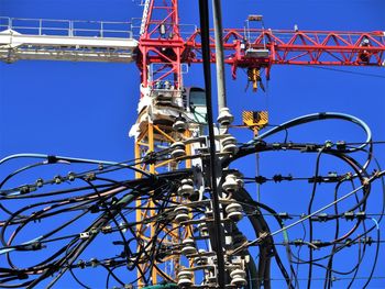 Low angle view of crane against clear blue sky