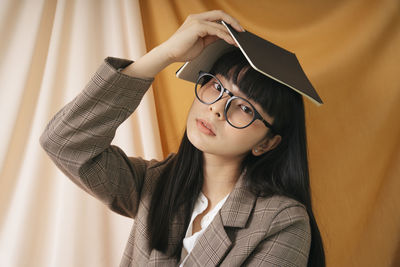 Portrait of young woman holding eyeglasses