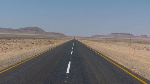Desert road against clear sky