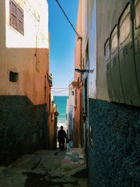 Rear view of people on alley amidst buildings