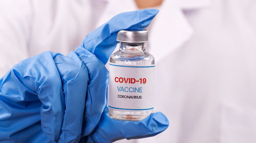 Close-up of man with text on bottle