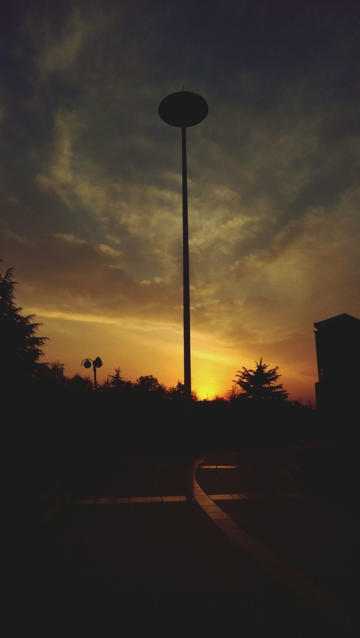 sunset, silhouette, transportation, sky, street light, cloud - sky, road, tree, land vehicle, car, orange color, street, mode of transport, lighting equipment, dark, cloud, nature, cloudy, no people, dusk