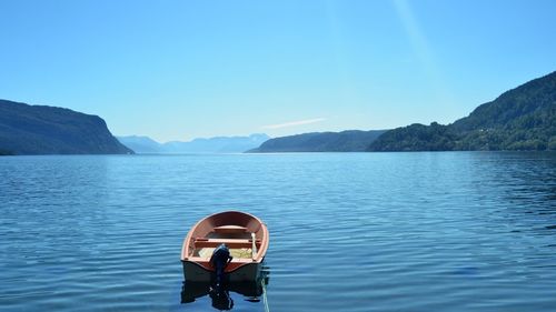 Rear view of man in water against blue sky