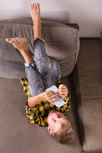 High angle view of woman lying on sofa