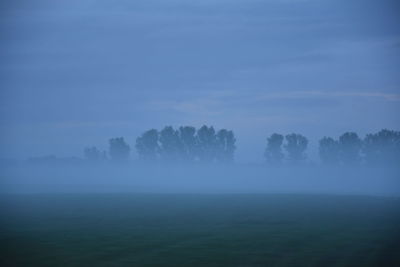 Scenic view of landscape against sky during foggy weather