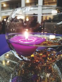 Close-up of illuminated tea light candle on table