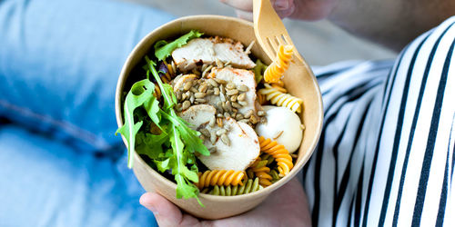 Midsection of person holding ice cream in plate