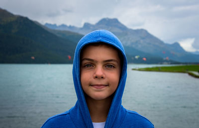 Portrait of smiling young boy against lake