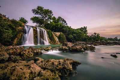 Scenic view of waterfall against sky