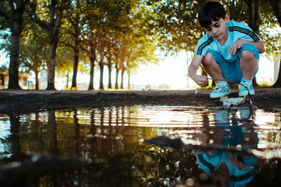 Little boy playing near the lake