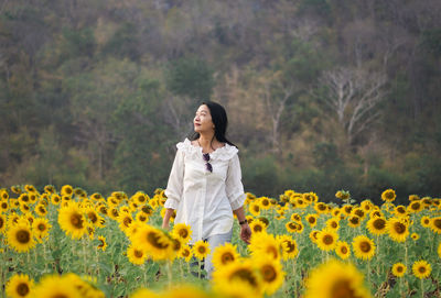 Portrait of young woman standing on field