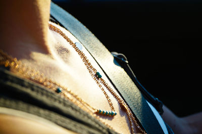 Midsection of woman wearing necklace while traveling in car