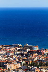 High angle view of townscape by sea against clear sky