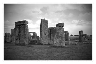 Old ruin on field against cloudy sky