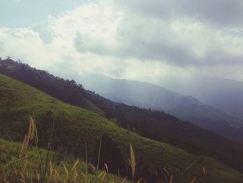 Scenic view of mountains against cloudy sky