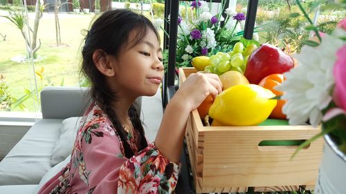 Side view of girl with toy fruits