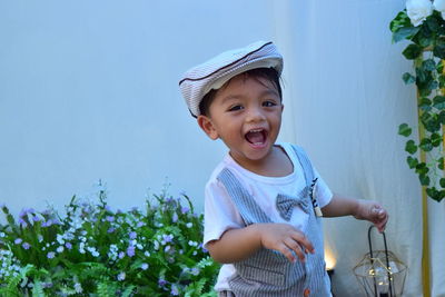 Portrait of smiling boy standing against plants