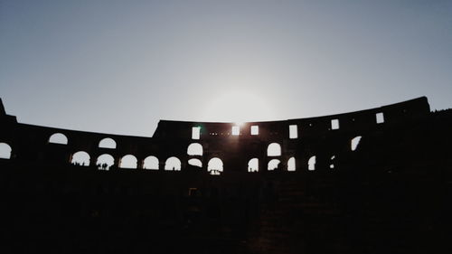 Low angle view of silhouette built structure against sky