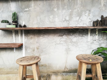 Empty chairs and table against wall