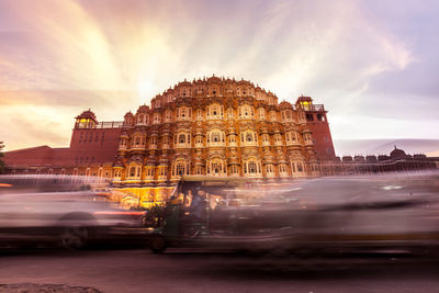 Blurred motion of jinrikisha by hawa mahal against cloudy sky