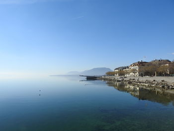 Scenic view of lake against clear blue sky