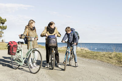 Happy friends with bicycles on seaside