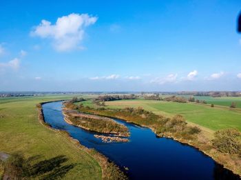 Scenic view of river against blue sky