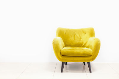 Close-up of yellow chair against white background