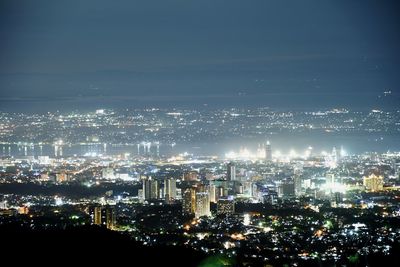 High angle view of illuminated city against sky at night