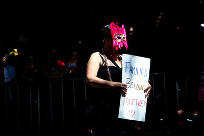 Midsection of woman holding text at night