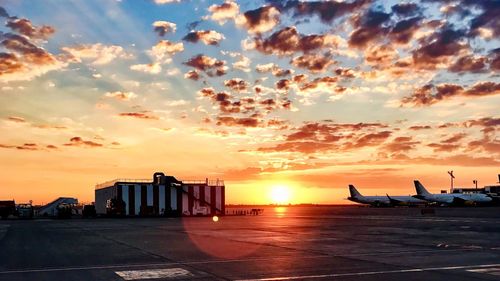 Airport runway against sky during sunset